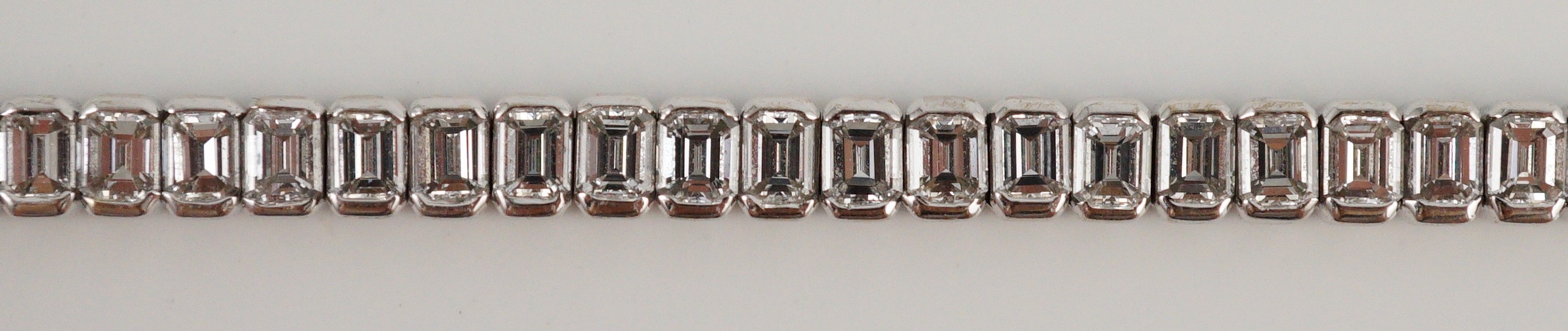 A modern 18ct white gold and emerald cut diamond set line bracelet